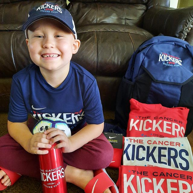 Cancer Kickers Teammate with kit sitting on couch holding water bottle with logo